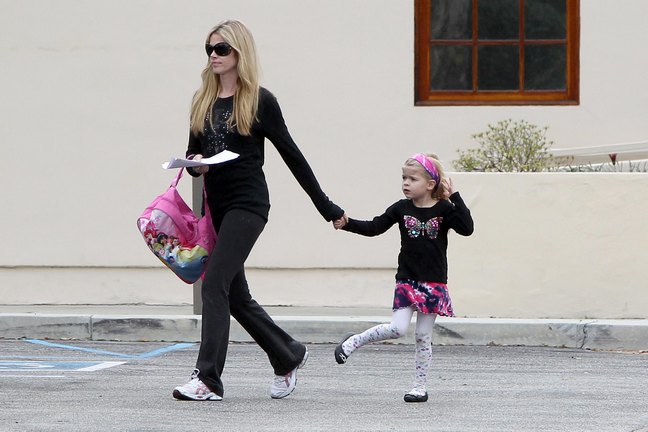 Denise Richards, black yoga pants, black sunglasses, black top, black longsleeve shirt